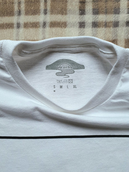 Inside neck of white t-shirt with a logo and size chart