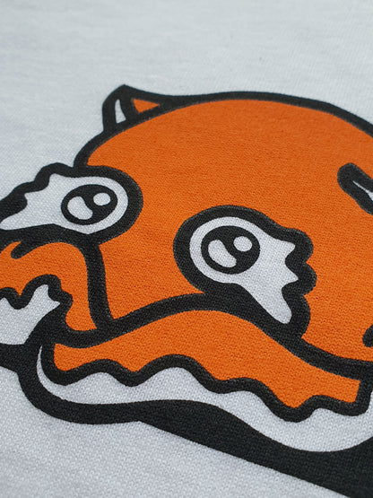Close-up of an orange and black cartoon character on a white T-shirt